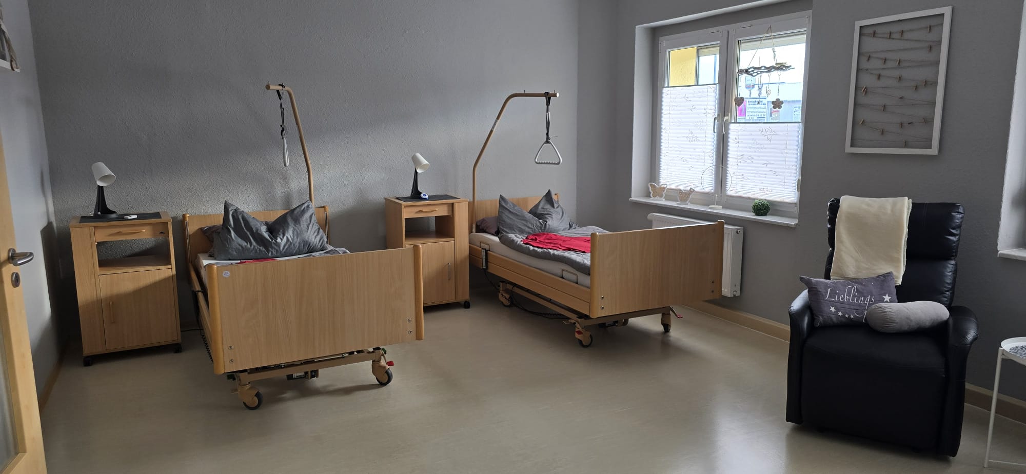 Pflegezimmer mit Bett und Sitzbereich in Hettstedt